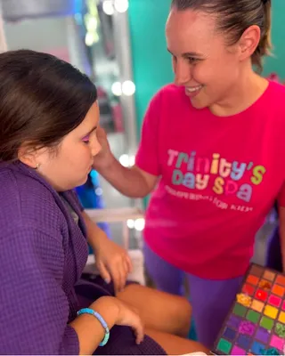 Child wearing glam makeup with eyeshadow and lip gloss