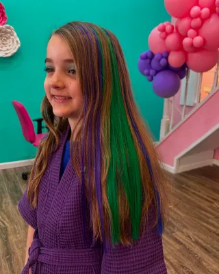 Child with a rainbow-colored clip-in hair extension